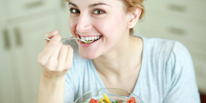 woman-laughing-alone-with-salad